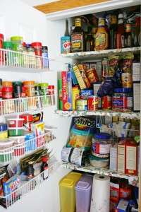Full white pantry with wire baskets and floral shelves